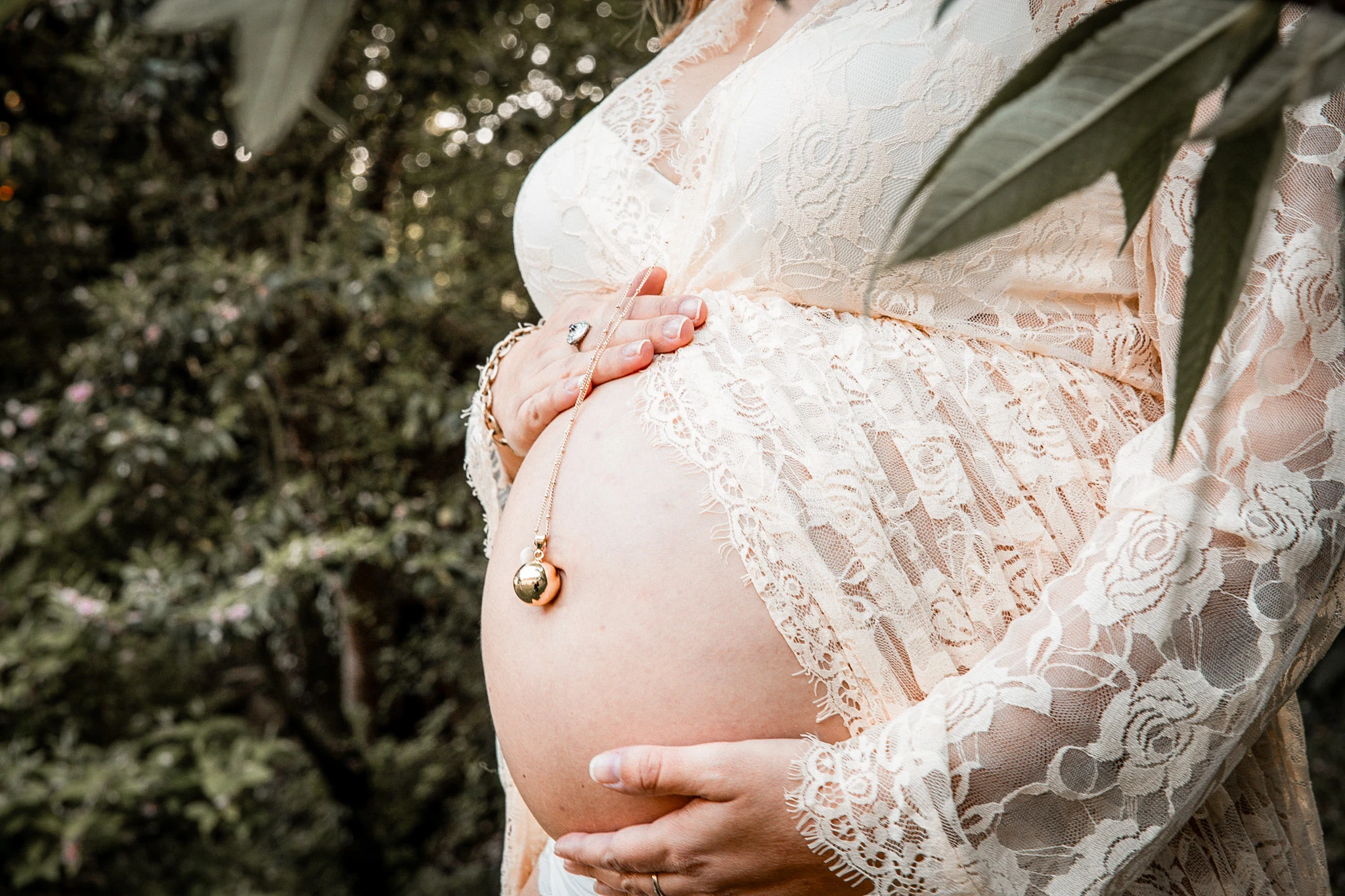 An expectant mother rests her hands on her belly