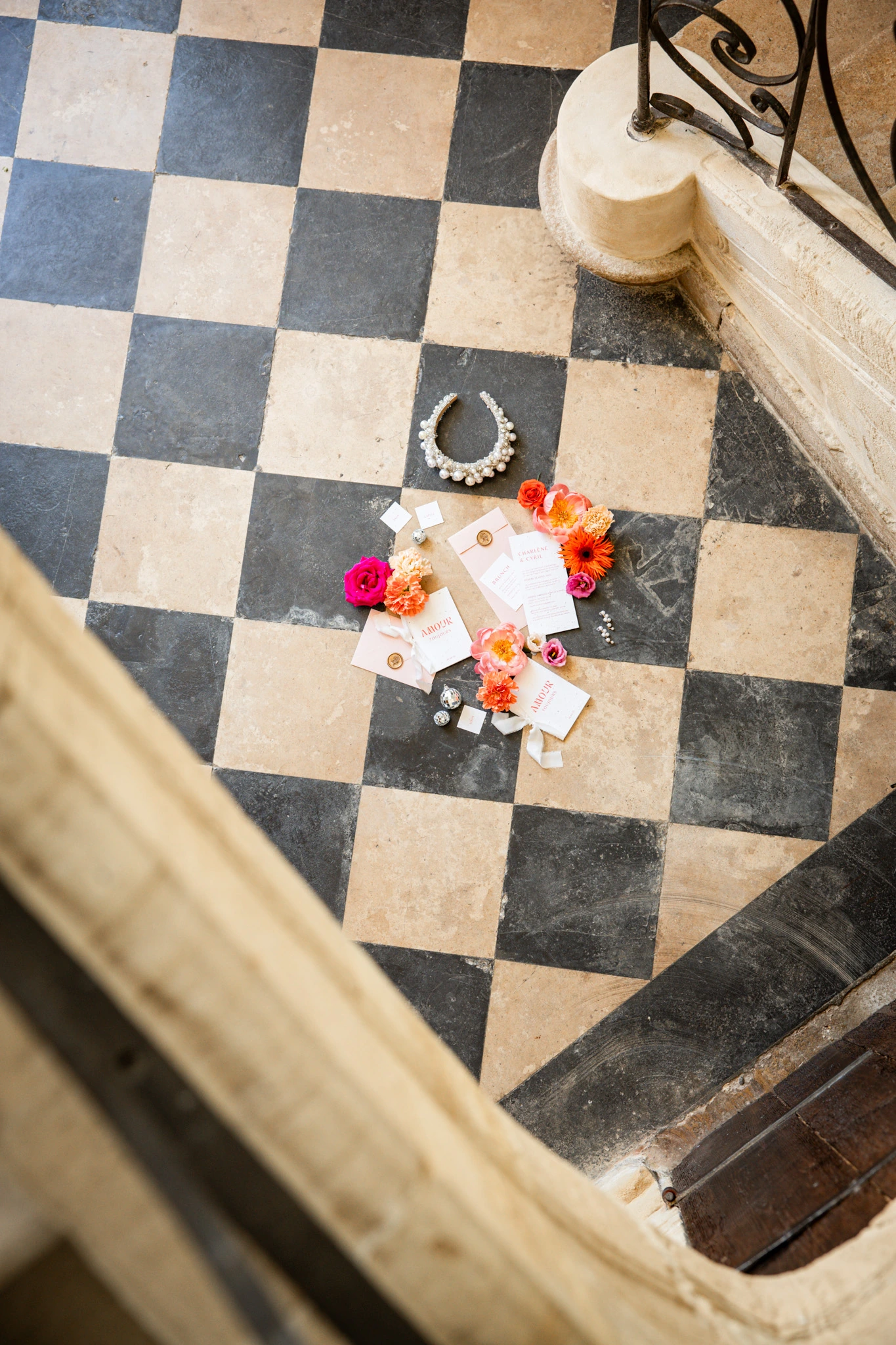 Wedding flowers and stationery arranged on a stone floor